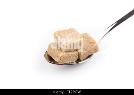 Würfel aus braunem Zucker auf einem Metalllöffel Stockfoto