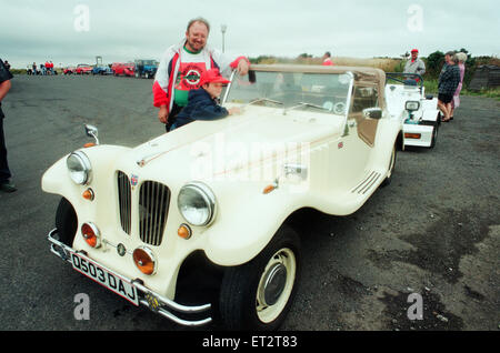 Bausatzfahrzeuge Kopf ab in einem Konvoi auf der Moor-Straße in Whitby, 6. August 1994. Im Bild. Sian Reece hilft Papa John, den letzten Schliff zu seinem Yachthafen basieren Roadster setzen. Stockfoto