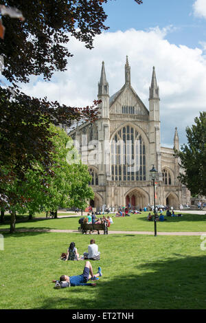 Winchester Kathedrale Hampshire UK im Sommer mit Menschen, die in den Park und die umliegenden Gärten entspannen Stockfoto