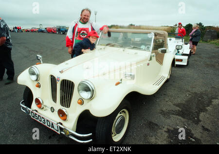 Bausatzfahrzeuge Kopf ab in einem Konvoi auf der Moor-Straße in Whitby, 6. August 1994. Im Bild. Sian Reece hilft Papa John, den letzten Schliff zu seinem Yachthafen basieren Roadster setzen. Stockfoto