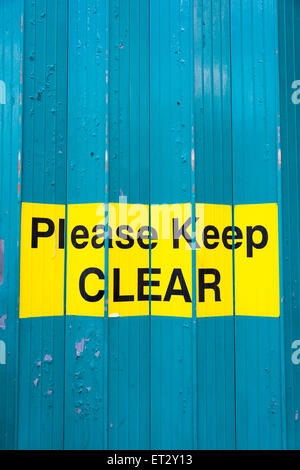 Bitte halten Sie klar Zeichen auf eine Falttür auf ein Geschäftshaus Stockfoto