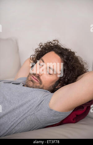 Mitte erwachsenen Mannes auf Schlafcouch, München, Bayern, Deutschland Stockfoto