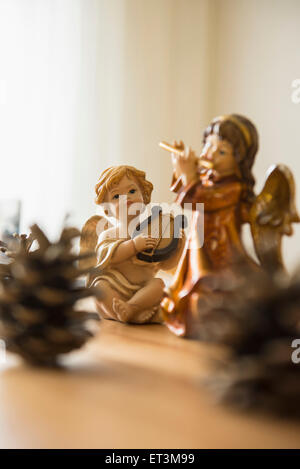 Dekorative weihnachtsengelfiguren mit Musikinstrumenten und Tannenzapfen auf dem Tisch, Bayern, Deutschland Stockfoto