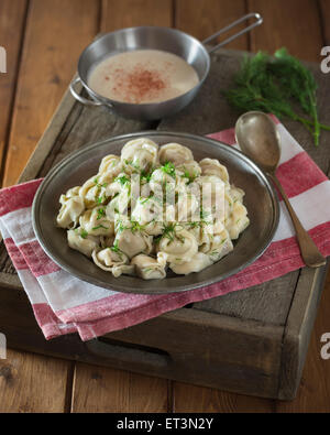 Pelmeni mit saurer Sahne und Dill. Russische gefüllte Teigtaschen. Russland-Essen Stockfoto