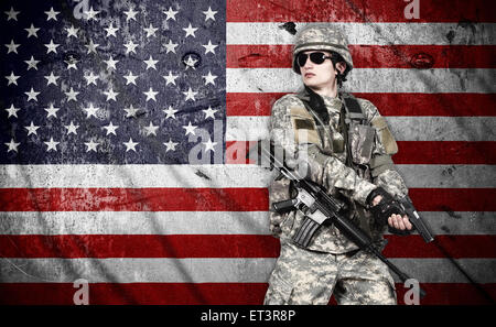 US-Soldat mit Gewehr auf eine amerikanische Flagge Hintergrund Stockfoto