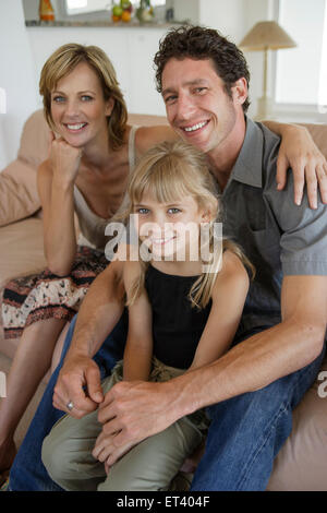 Familie mit Tochter auf der Couch, Blick in die Kamera Stockfoto