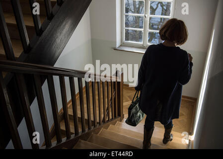 Rückansicht des senior Trägerin Wintermantel nach unten bewegen, auf einer Treppe, München, Bayern, Deutschland Stockfoto