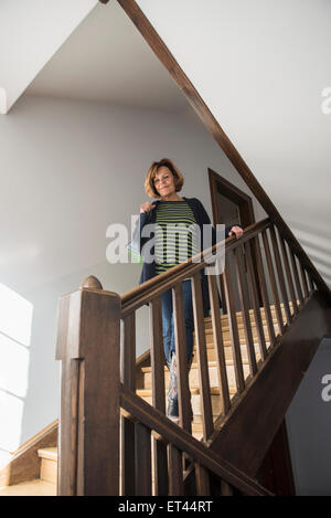 Ältere Frau trägt Wintermantel nach unten bewegen, auf einer Treppe, München, Bayern, Deutschland Stockfoto