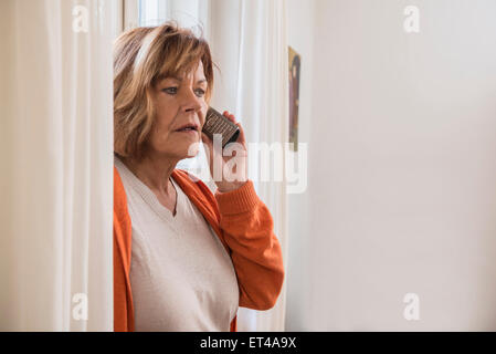 Ältere Frau im Gespräch auf dem Handy schauen schockiert, München, Bayern, Deutschland Stockfoto