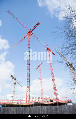 Niedrigen Winkel Ansicht von Kränen am Bau Website bewölkten Himmel, Bayern München Stockfoto