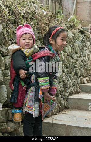 Kleines Basha Miao-Mädchen mit einem großen Bruder auf ihrem Rücken, Basha Gun Dorf, Guizhou Provinz, China Stockfoto