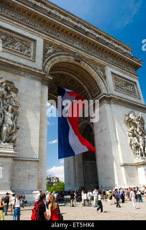 Der französischen Tricolore fliegt unter dem Arc de Triomphe am Nationalfeiertag in Paris Stockfoto