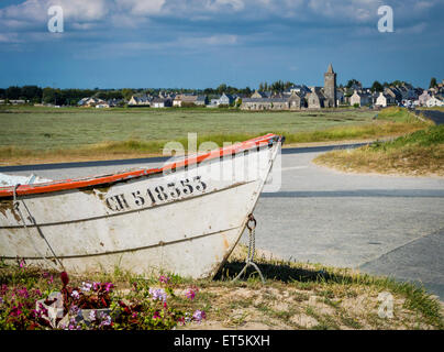 Blick auf einen Teil eines Segelbootes mit der Stadt Portbail, Normandie, Frankreich in der Ferne Stockfoto