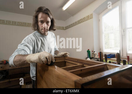 Tischler Französisch Polieren auf Holzschublade in Werkstatt, Bayern, Deutschland Stockfoto