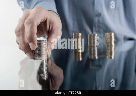 Geschäftsmann's Hand Stapelmünzen, Bayern, Deutschland Stockfoto