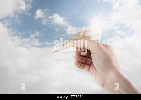 Menschliche Hand mit Papierflieger gemacht aus Geld, Bayern, Deutschland Stockfoto