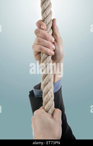 Geschäftsmanns Hände ziehen Seil, Bayern, Deutschland Stockfoto