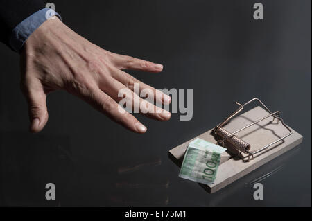 Die Hand des Geschäftsmannes, die nach Geld greift, in der Mauserfalle, Bayern, Deutschland Stockfoto