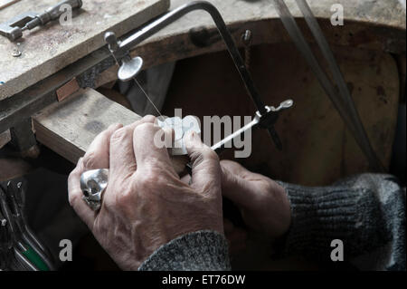 Senior Goldschmied Gestaltung Kristall mit Hand sah in Werkstatt, Bayern, Deutschland Stockfoto