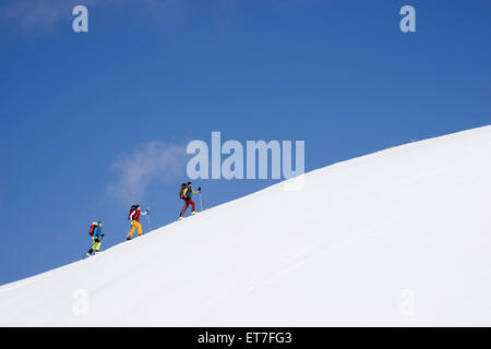 Skibergsteiger Klettern auf schneebedeckten Gipfel, Tirol, Österreich Stockfoto