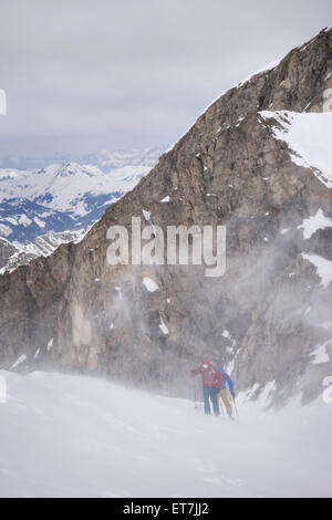 Skibergsteiger Klettern auf verschneiten Bergen im Schneesturm, Zell Am See, Österreich Stockfoto