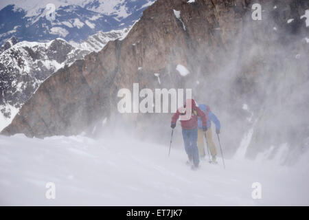 Skibergsteiger Klettern auf verschneiten Bergen im Schneesturm, Zell Am See, Österreich Stockfoto