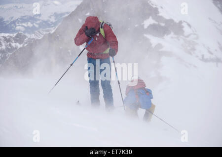 Skibergsteiger Klettern auf verschneiten Bergen im Schneesturm, Zell Am See, Österreich Stockfoto