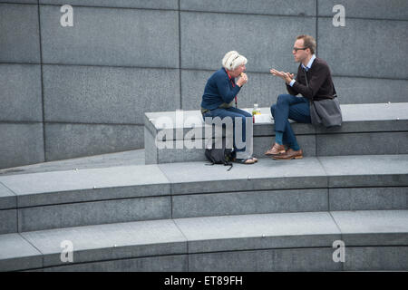 2 Personen essen Mittagessen auf den Stufen mehr London neben dem Rathaus in ihrer Mittagspause bei der Arbeit Stockfoto