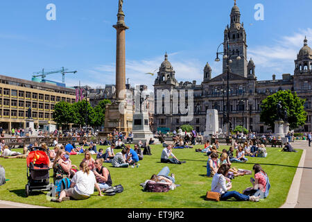 Glasgow, Schottland. 12. Juni 2015. Zur Mittagszeit viele Menschen aus der Stadtzentrum Büros, Shopper und Touristen sich ihre Pause vom Sonnenbaden in den offenen Bereichen des George Square erfreuen im Stadtzentrum von Glasgow wo mit sonnigen Himmel, die Temperatur stieg auf 24 C Credit: Findlay/Alamy Live News Stockfoto