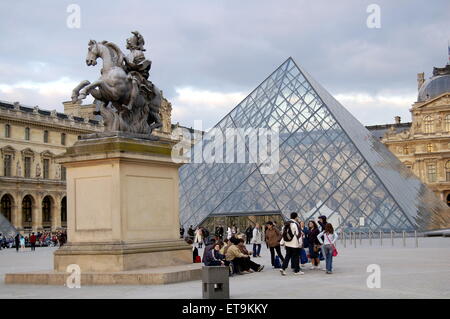 Der Louvre in Paris. Die berühmte Glaspyramide mit der Statue von König Louis XIV von Frankreich auf dem Pferd im Vordergrund. Stockfoto