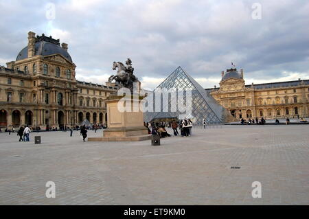 Der Louvre in Paris. Die berühmte Glaspyramide mit der Statue von König Louis XIV von Frankreich auf dem Pferd im Vordergrund. Stockfoto