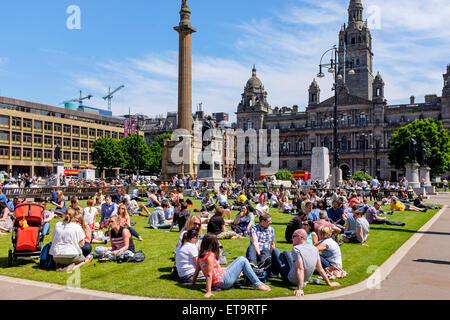 Glasgow, Schottland. 12. Juni 2015. Zur Mittagszeit viele Menschen aus der Stadtzentrum Büros, Shopper und Touristen sich ihre Pause vom Sonnenbaden in den offenen Bereichen des George Square erfreuen im Stadtzentrum von Glasgow wo mit sonnigen Himmel, die Temperatur stieg auf 24 C Credit: Findlay/Alamy Live News Stockfoto