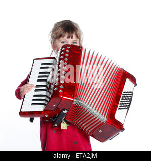 sehr junges Mädchen mit Ziehharmonika im Studio vor weißem Hintergrund Stockfoto