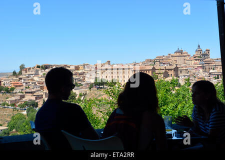 Silhouette von drei Personen mit Blick auf Toledo im Hintergrund vom sitzen im restaurant Stockfoto