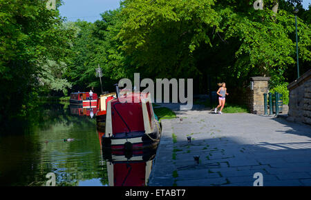 Jogger auf dem Treidelpfad von Leeds und Liverpool Canal, Saltaire, West Yorkshire, England UK Stockfoto