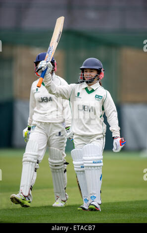 Ein Schlagmann feiert ihr 50 Junior während ein Mädchen-Cricket-Match in Wiltshire UK Stockfoto