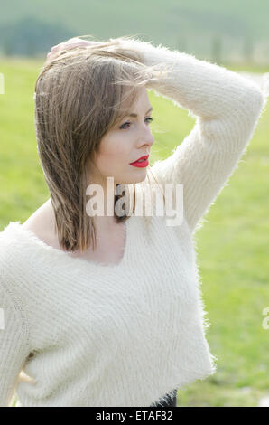 Schöne junge Frau Hand zu berühren, Haare wegschauen Stockfoto