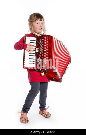 sehr junges Mädchen mit Ziehharmonika im Studio vor weißem Hintergrund Stockfoto