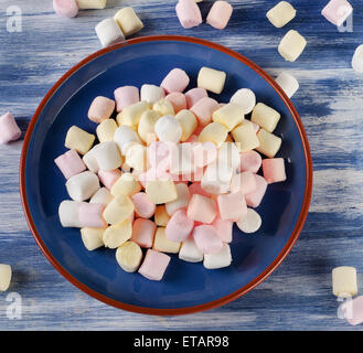 Bunte kleine Marshmallows auf blauem Grund. Stockfoto