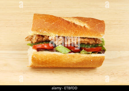 Wir fuhren Schweinefleisch und Salat in ein knuspriges Brot Rollen auf einem Holzbrett Stockfoto