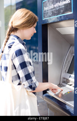 Frau an der Cash-Maschine, indem ihre Pin in. Stockfoto