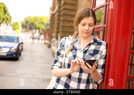 junge Frau, die eine SMS in london Stockfoto