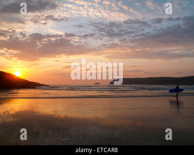 Surfer verlassen Polzeath Strand bei Sonnenuntergang Stockfoto