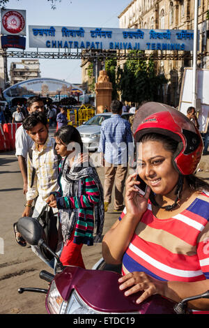 Mumbai Indien, Fort Mumbai, Chhatrapati Shivaji Bahnhof Terminus Bereich, Frau weibliche Frauen, Motorroller, Smartphone-Handys SMS, Kommu Stockfoto