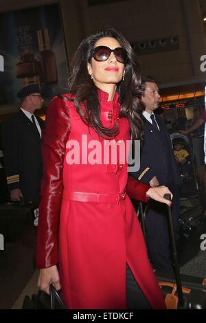 Amal Clooney, trug eine Sonnenbrille und einen leuchtend roten voller Länge Mantel, bereitet sich auf einen Flug am Los Angeles International Airport (LAX) mit an Bord: Amal Clooney wo: Los Angeles, California, Vereinigte Staaten von Amerika bei: 25. Januar 2015 Credit: WENN.com Stockfoto