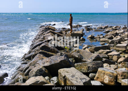 Eine Skulptur aus Gusseisen von Sir Antony Gormley steht auf den Felsen in der Nähe von Clavell Tower im Kimmeridge Bay, Dorset, Großbritannien Stockfoto