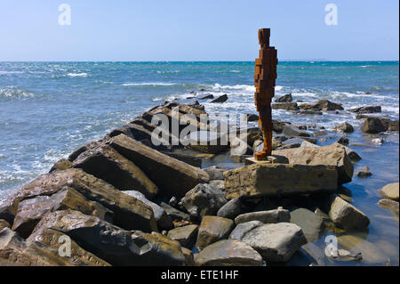 Eine Skulptur aus Gusseisen von Sir Antony Gormley steht auf den Felsen in der Nähe von Clavell Tower im Kimmeridge Bay, Dorset, Großbritannien Stockfoto