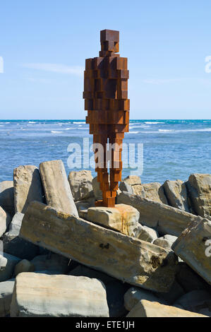 Eine Skulptur aus Gusseisen von Sir Antony Gormley steht auf den Felsen in der Nähe von Clavell Tower im Kimmeridge Bay, Dorset, Großbritannien Stockfoto