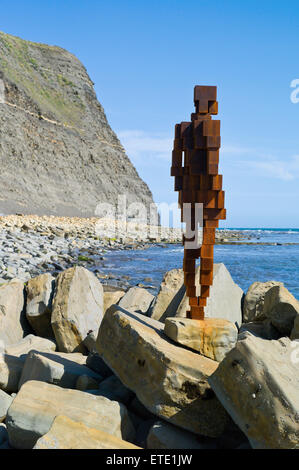 Eine Skulptur aus Gusseisen von Sir Antony Gormley steht auf den Felsen in der Nähe von Clavell Tower im Kimmeridge Bay, Dorset, Großbritannien Stockfoto