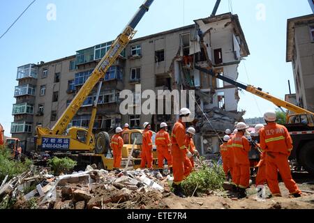 Huludao, Chinas Liaoning Provinz. 12. Juni 2015. Retter arbeiten an der Unfallstelle, wo in Huludao Stadt, Nordost-China Liaoning Provinz, 12. Juni 2015 eine Explosion stattfand. Eine Person starb und zwei weitere werden vermisst, nachdem eine Explosion eines Wohnhauses am Freitagmorgen in Huludao zerriss. Neun Bewohner wurden aus den Trümmern gerettet und ein Dutzend Verletzte, darunter drei Fußgänger, wurde ins Krankenhaus eingeliefert. Die Explosion war vermutet worden, durch verflüssigtes Gas-Leck verursacht werden. © Pan Yulong/Xinhua/Alamy Live-Nachrichten Stockfoto